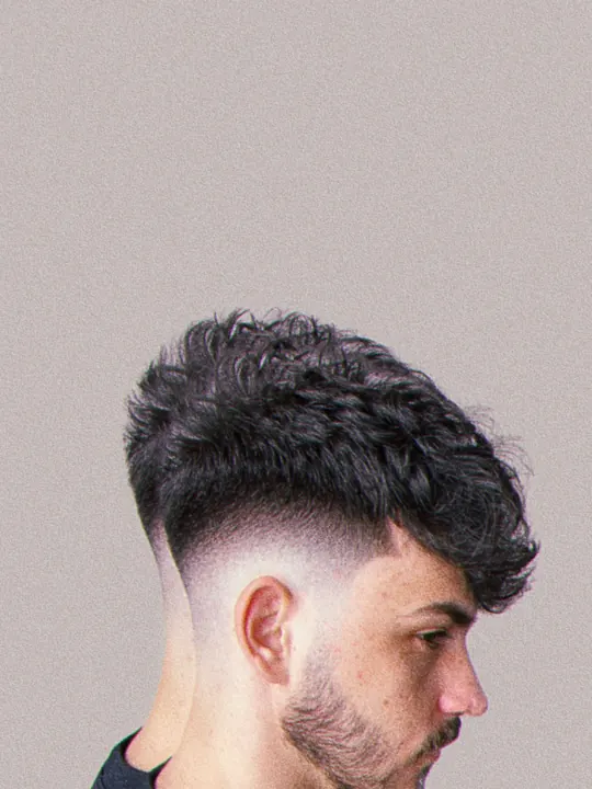 Textured curly top with a fade, side profile