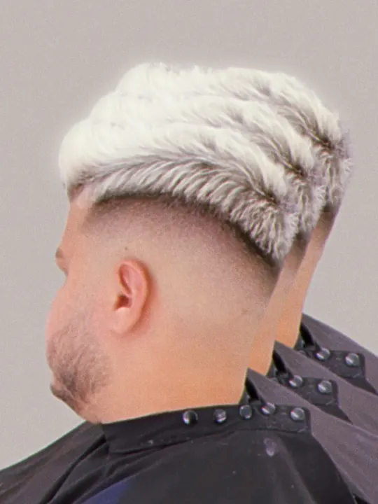 Platinum blond textured crop with a fade, seen from behind